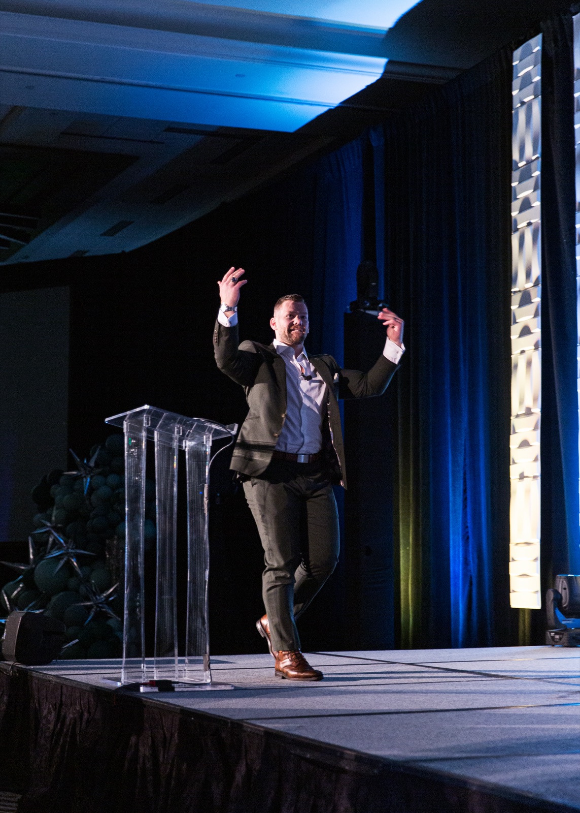 Josh Littauer speaking from the stage at a WealthWave leadership event